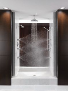 a large shower in the middle of a room with two doors open and water coming from it