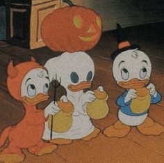 three little ducks are standing next to each other in front of a pumpkin and jack - o'- lantern