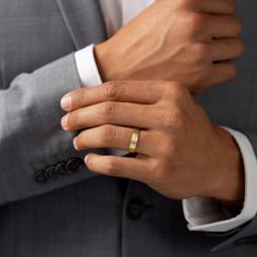 a man in a suit with a wedding ring on his finger