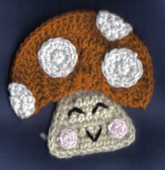 a crocheted mushroom hat with eyes and nose