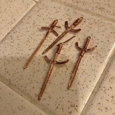 three metal swords are sitting on a tile floor