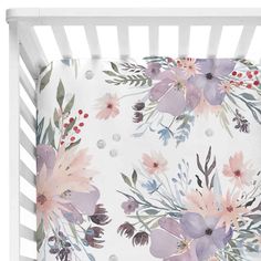 a white crib with pink and purple flowers on it