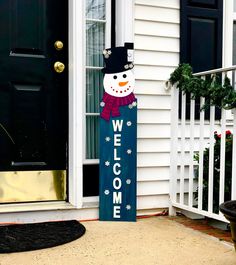 a welcome snowman sign sitting in front of a door