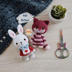 two crocheted stuffed animals sitting next to each other on a table with scissors