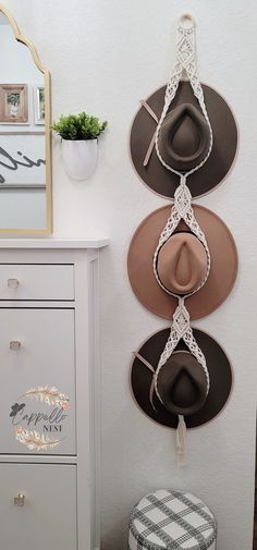 three hats are hanging on the wall next to a dresser