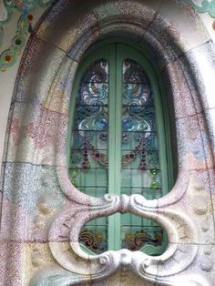 an ornate window in the side of a building with stained glass and stone work on it