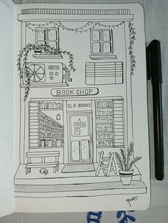 a black and white drawing of a book shop on a piece of paper next to a pen