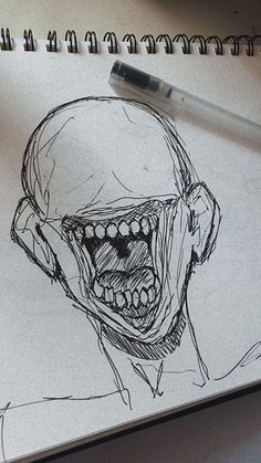 a drawing of a man's face with teeth and mouth wide open, next to a pen