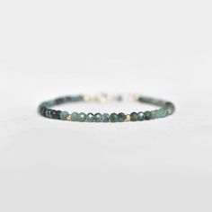 "Say hello to the daintiest emerald bracelet there ever was. It features a most elegant selection of genuine, natural gemstones, so you may notice oh-so-subtle variations from stone to stone. This bracelet makes a wonderful gift for someone with a May birthday, or any emerald lover in your family or friend circle. To find your bracelet size, simply measure the circumference of your wrist by wrapping a string around it and measuring the length of the string. Round up to the nearest half inch for Minimalist Adjustable Emerald Jewelry, Elegant May Birthstone Beaded Bracelets, Dainty May Birthstone Bracelets, Dainty May Birthstone Bracelet, Adjustable Emerald Gemstone Bracelet, May Birthstone Gemstone Bracelets With Round Beads, Minimalist Gemstone Bracelets For May Birthstone, Handmade Everyday Bracelets For May Birthstone, Handmade Everyday Bracelet For May Birthstone