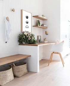 a white room with wooden shelves and baskets on the wall, along with a bench