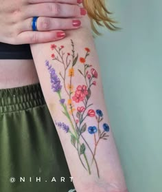 a woman's arm with flowers painted on it