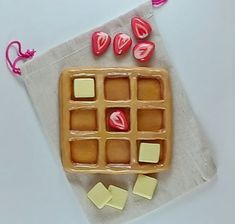 a waffle with marshmallows and hearts on it sitting on a napkin