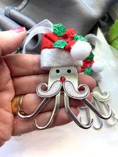 a person is holding a christmas ornament with an octopus in it's mouth