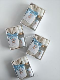 three small boxes with bottles in them on a white surface, one is empty and the other has a blue bow