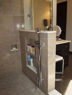 a walk in shower sitting inside of a bathroom next to a sink and counter top