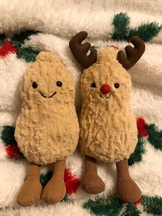 two stuffed animals laying on top of a blanket