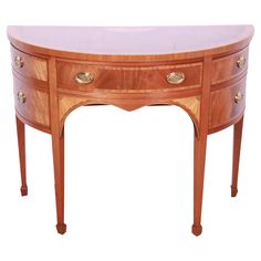 an oval shaped table with two drawers on the top and one drawer at the bottom