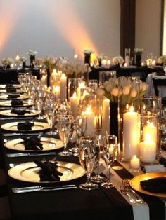 a long table is set with candles and place settings for formal dinner guests to enjoy