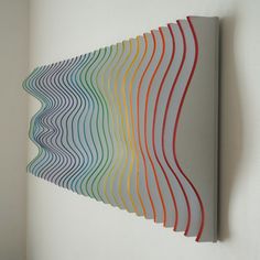 an abstract art piece with wavy lines painted on it's side and in front of a white wall