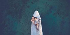 two women laying on the back of a white boat in the middle of the ocean