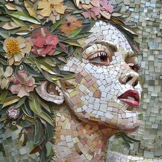 a woman's face is made up of mosaic tiles and flowers, with leaves on it