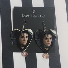 a pair of heart shaped earrings with an image of the character edward stewart on them