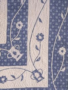 a blue and white quilt with flowers on it