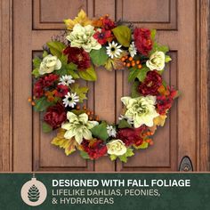 the front door is decorated with fall foliage and flowers