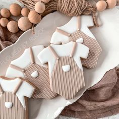 some cookies are laying on a plate next to string of twine and balls of yarn