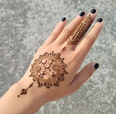 a woman's hand with henna tattoos on it