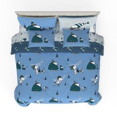 a bed covered in blue and white sheets with cartoon animals on the cover, along with two pillow cases