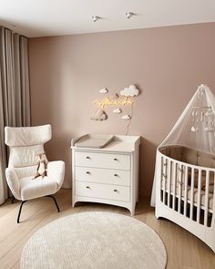 a baby's room with a crib, chair and dresser