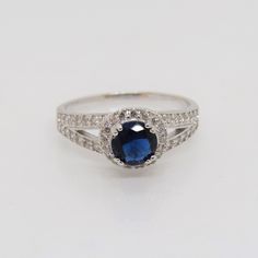 Vintage Sterling Silver Blue Sapphire & White Topaz Halo Ring...Marked 925...Total of weights 2.8grams...Size 6,9...Measure of stone center 5.8MM...It's in very good condition. Sapphire Color Topaz Ring With Brilliant Cut, Fine Jewelry Sapphire Topaz Round Ring, Blue Topaz Ring With Center Stone In Round Band, Blue Jewelry With Round Cut Center Stone, Sapphire Rings With Diamond Accents And Blue Topaz, Fine Jewelry With Blue Center Stone, Blue Sterling Silver Birthstone Ring With Center Stone, Sterling Silver Blue Topaz Ring With Center Stone, Classic Blue Jewelry With Halo Setting