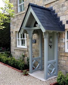 a small house with a black roof and white trim on the side of it's building