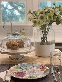 there is a plate with muffins on it next to a glass cake stand