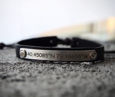 a black leather bracelet with an engraved name on it