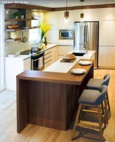 a modern kitchen with an island counter and stools