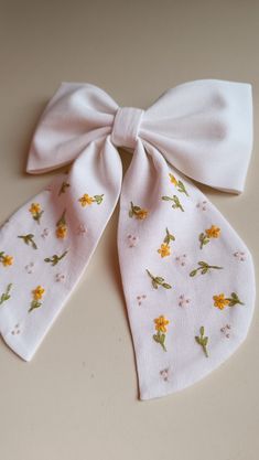 a white bow with yellow flowers on it