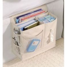 a white storage bag filled with books on top of a bed