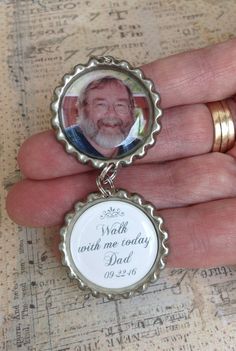 a hand holding a silver bottle cap with a photo on the front and back of it