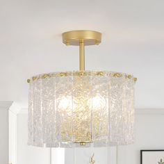 a chandelier hanging from the ceiling in a room with white walls and furniture