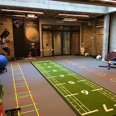 an indoor game room with foo - o - mat, football field and exercise equipment