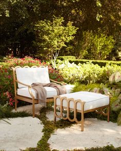 a chair and ottoman in the middle of a garden