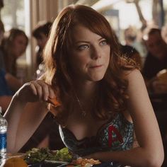 a woman sitting at a table with food in front of her