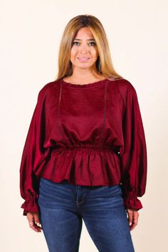 Add feminine flair to your wardrobe with a delicate blouse featuring a round neckline, an elastic waist peplum hem and baby bell sleeves. Pair it with some skinnies and cute booties or pumps. -Color: Burgundy -Relaxed Fit -Stretchy -Round Neckline -Long Sleeves with Elastic Cuffs -Elastic Waistband -Back Keyhole with Neckline Button Closure -Content:100% Polyester -Imported -Runs true to size -Model is wearing 5'5" 36-30-40 and wearing a size small Fall Solid Color Bell Sleeve Blouse, Chic Fall Peplum Top, Fall Peplum Top For Work, Fall Peplum Top For Workwear, Fall Season Peplum Top For Workwear, Fall Workwear Peplum Top, Casual Peplum Blouse For Fall, Chic Fall Peasant Top With Blouson Sleeves, Fall Ruffled Peplum Blouse