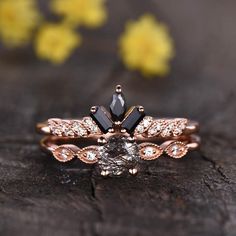 a close up of a ring on a piece of wood with flowers in the background