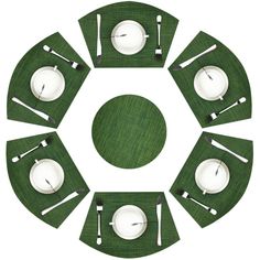 a green place setting with white plates and silverware in the shape of a circle