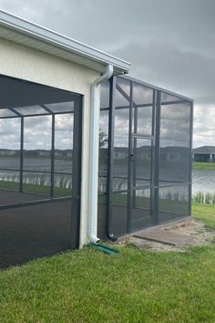 an open garage door on the side of a building next to a body of water