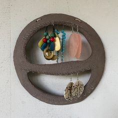 a circular metal object with beads and necklaces hanging from it