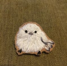 a small white bird sitting on top of a brown blanket